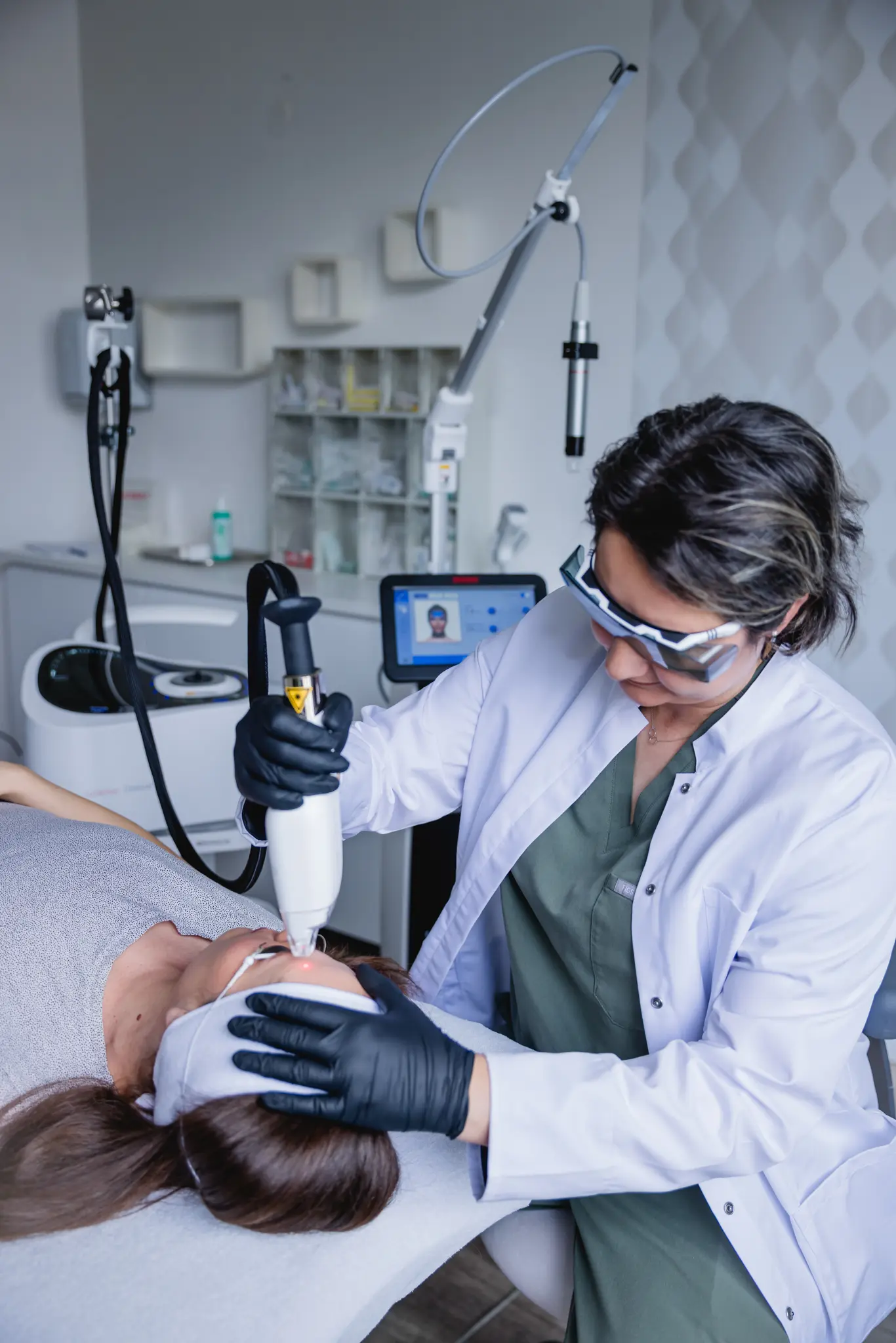 Ästhetische Laser-Hautbehandlung im Gesicht durch eine Behandlerin im weißen Kittel